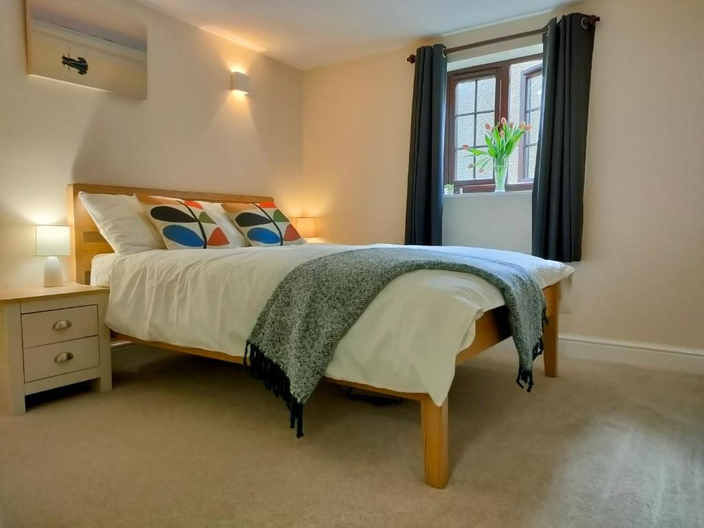 a bedroom with a large bed and a window at The Old Bakery Seahouses in Seahouses