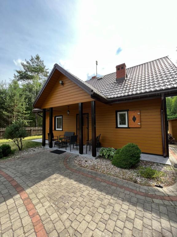 a small house with a patio in front of it at Leśne zacisze in Sucha Rzeczka