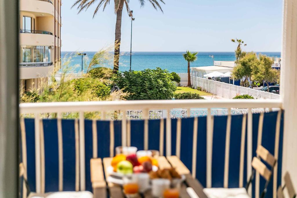 a table with fruit on a balcony with a view of the ocean at Sur Suites Astigi Vista Mar in Fuengirola