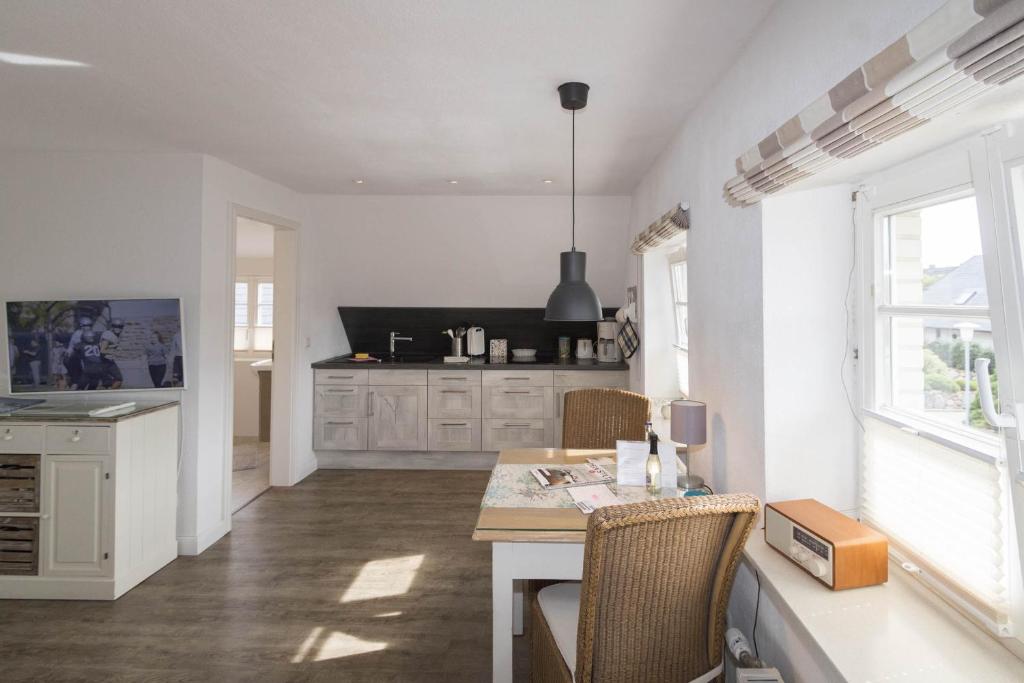 a kitchen with a table and chairs and a dining room at Haus Claßen in Hörnum