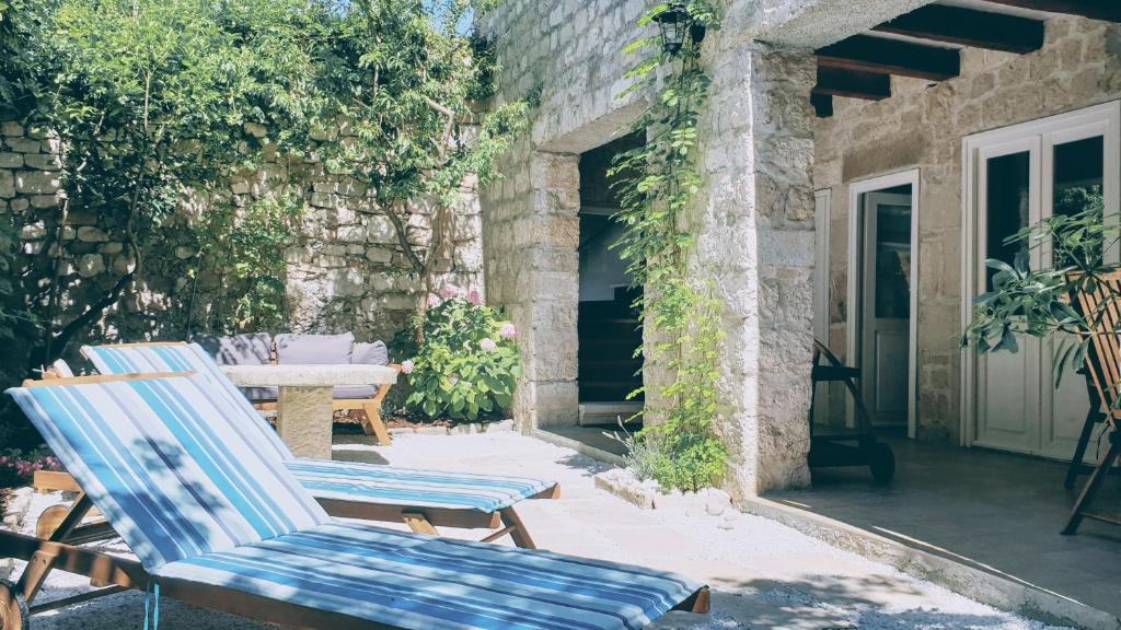 a couple of chairs sitting on a patio at Rector's Villa - Charming Retreat in Old Town with Jacuzzi in Private Courtyard in Rab