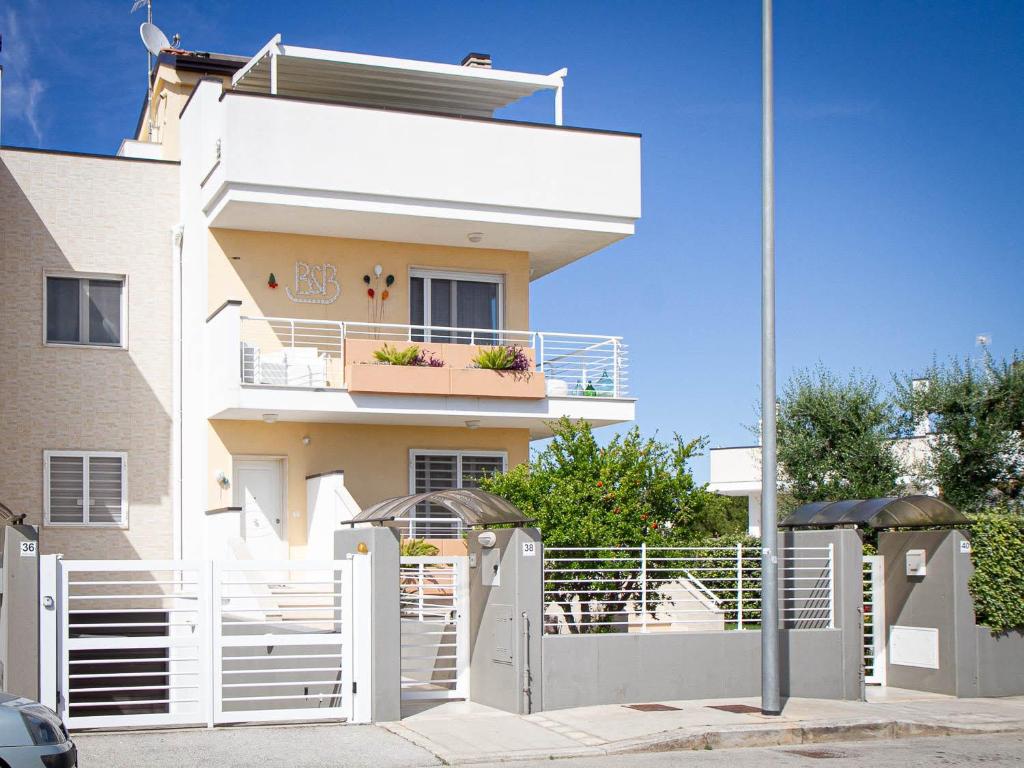 una casa bianca con una recinzione bianca e un edificio di B&B ALLA NIVIERA ad Adelfia