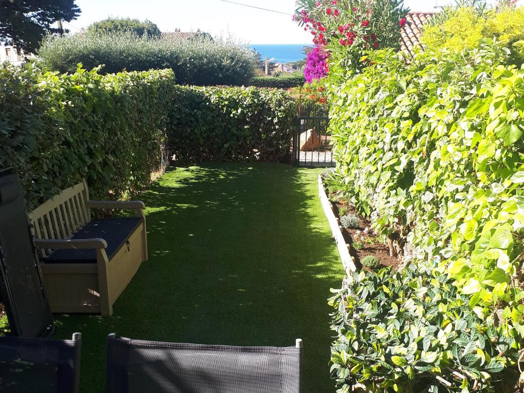 a garden with a bench in the middle of a yard at STUDIO BANDOL 2 Etoiles Climatisé in Bandol