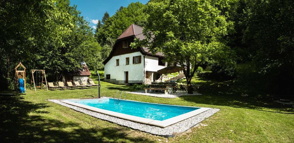 een zwembad in de tuin van een huis bij Gorska Vila mountain villa in Soča