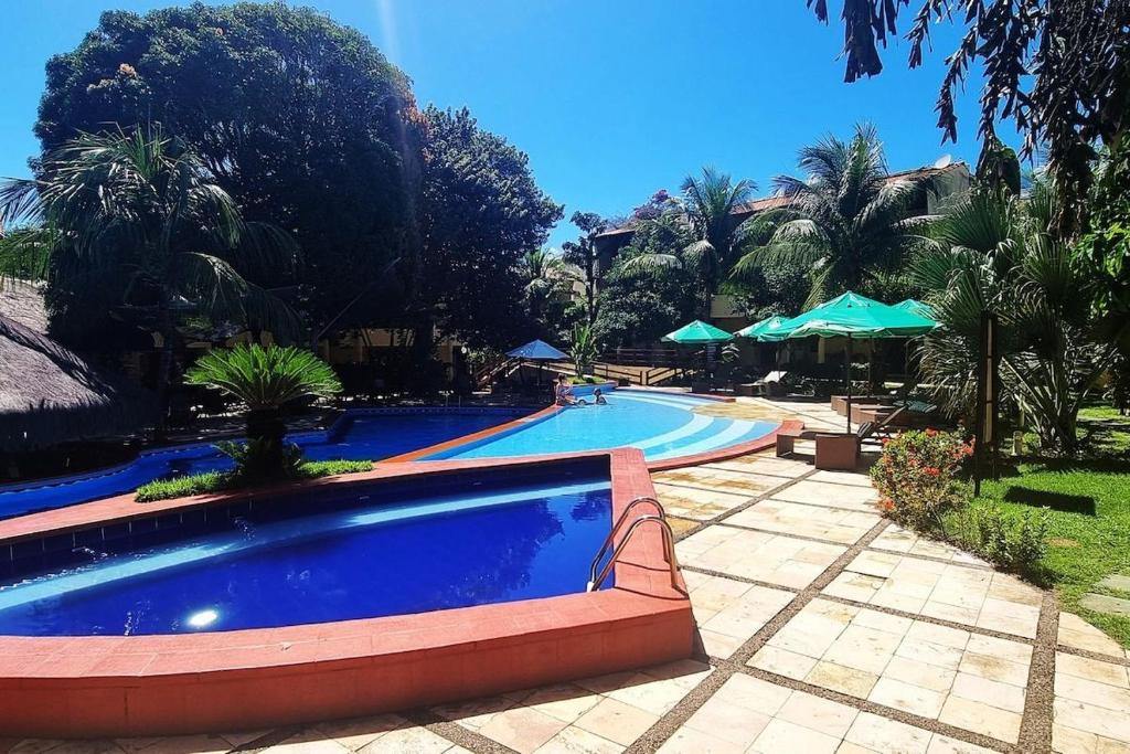 a large swimming pool in a resort with trees at Solar de Pipa Prime Flat - Frente Piscina in Pipa