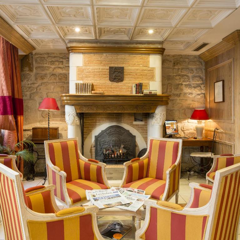 - un salon avec une cheminée, une table et des chaises dans l'établissement Elysees Niel Hotel, à Paris