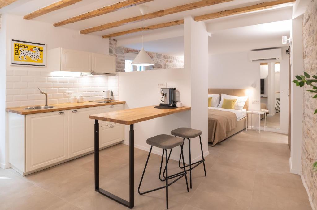 a kitchen and living room with a bed and a table at Vitelli Apartments and Rooms in Split