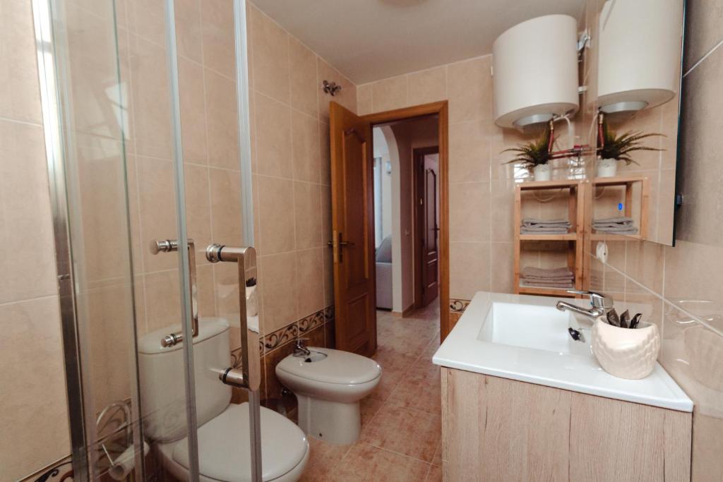 łazienka z toaletą, umywalką i prysznicem w obiekcie Apto ACHE, acogedor apartamento de 66 m con terraza, aire acondicionado y parking privado gratuito w mieście Los Abrigos