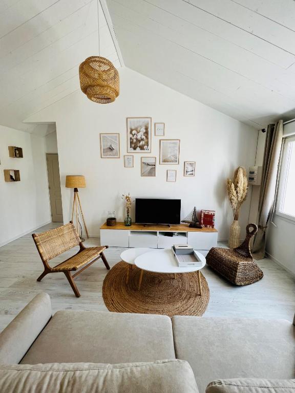 ein Wohnzimmer mit einem Sofa und einem Tisch in der Unterkunft Parenthèse insulaire in LʼÉpine