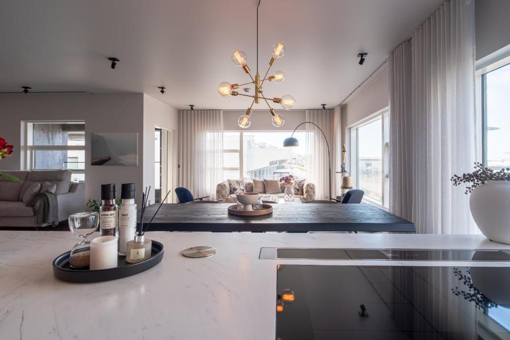 a living room with a table with a chandelier at Ocean Breeze Luxury Apartment in Reykjavík