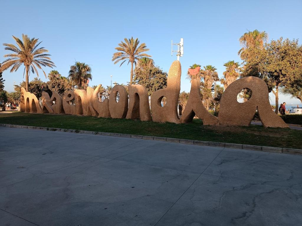 APARTAMENTOS LOS GUINDOS في مالقة: علامة كبيرة تقول ابولو في حديقة