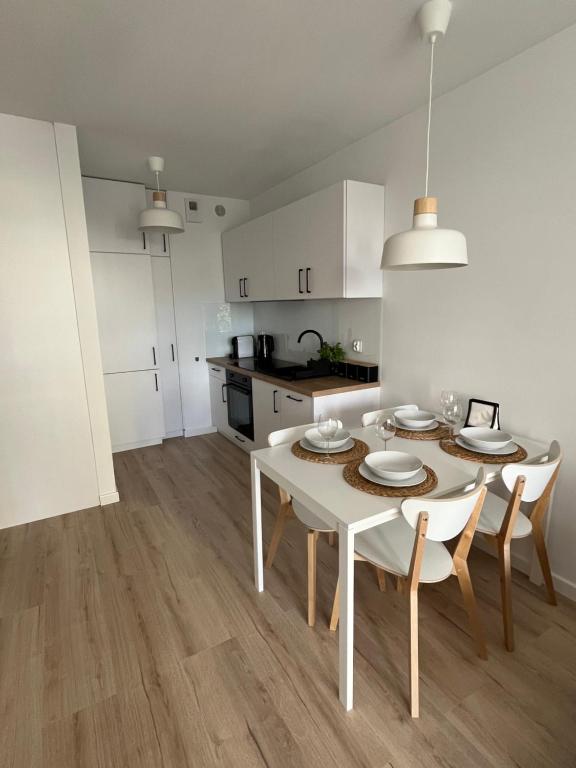 kuchnia i jadalnia z białym stołem i krzesłami w obiekcie Apartament 34 Sun Towers w Świnoujściu