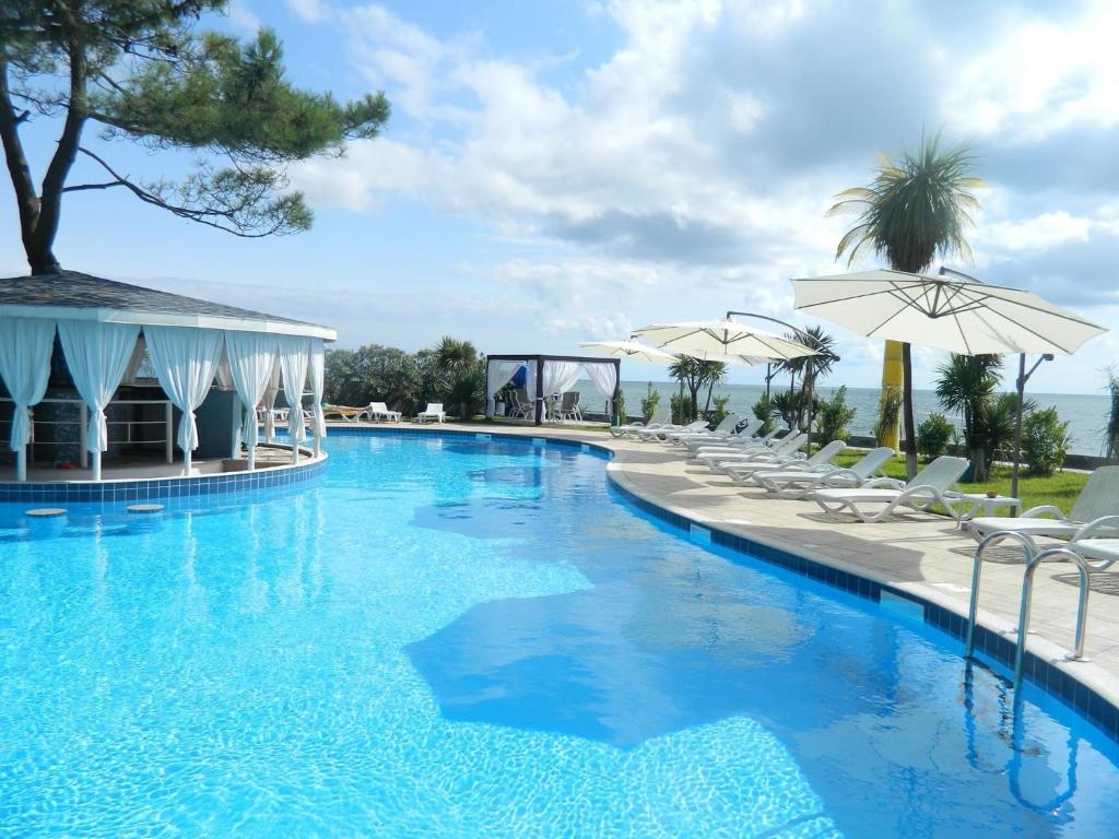 una piscina con sillas y sombrillas en un complejo en Andamati Beach Resort en Grigoleti