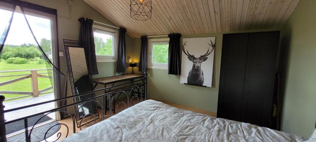 1 dormitorio con 1 cama y una foto de un ciervo en la pared en Cosy private cottage with stunning view, en Sunne