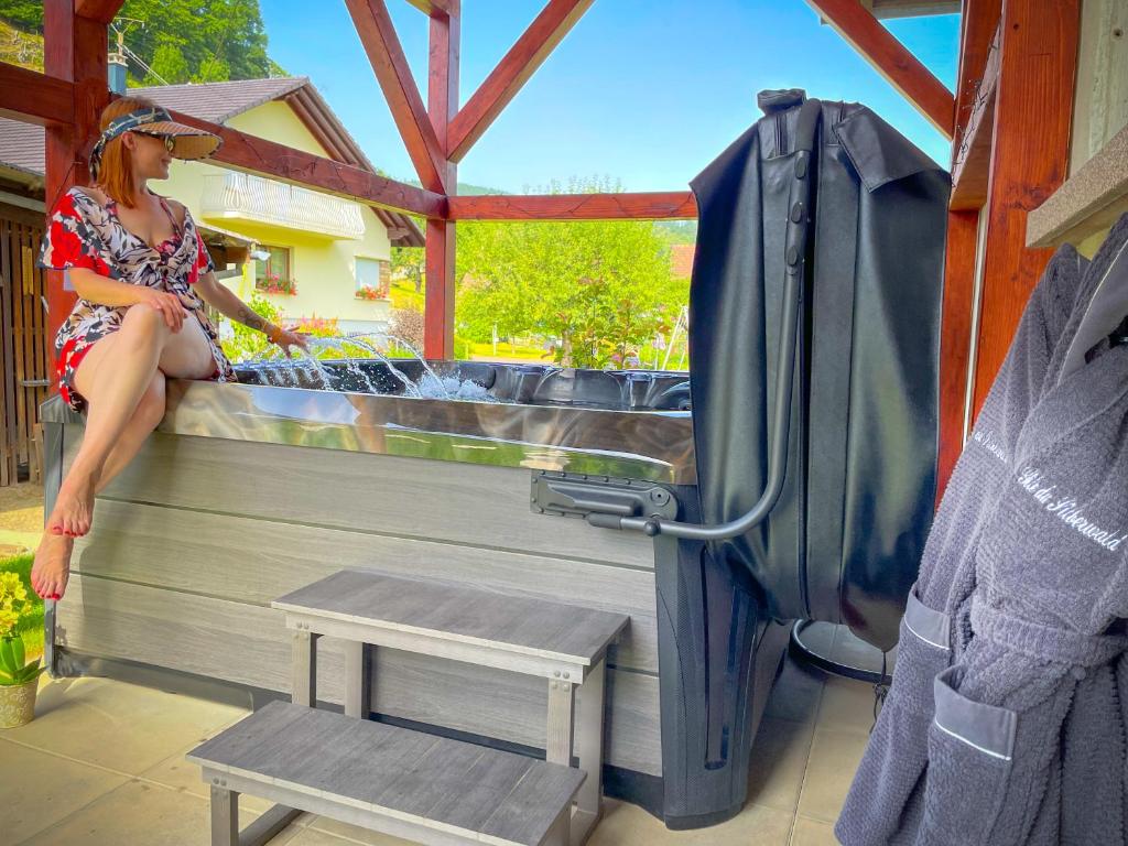 a woman sitting on the back of a truck at Gîte du Silberwald charmant gîte avec spa - jacuzzi , accès privatif in Stosswihr