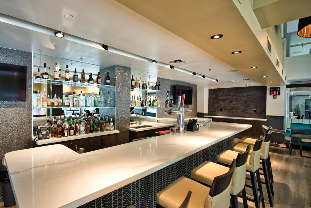 a bar with a white counter and some chairs at Holiday Inn Toronto Downtown Centre by IHG in Toronto