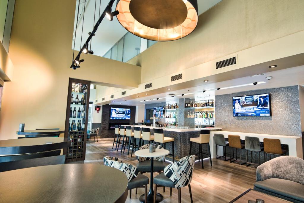 a restaurant with tables and chairs and a bar at Holiday Inn Toronto Downtown Centre by IHG in Toronto