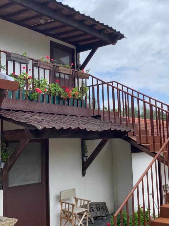 ein Gebäude mit einem Balkon mit Blumen darauf in der Unterkunft Estabulo de Valinhas in Vitorino dos Piães