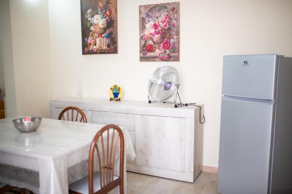 kuchnia z białym stołem i lodówką w obiekcie Casa Valeriana w mieście Sava