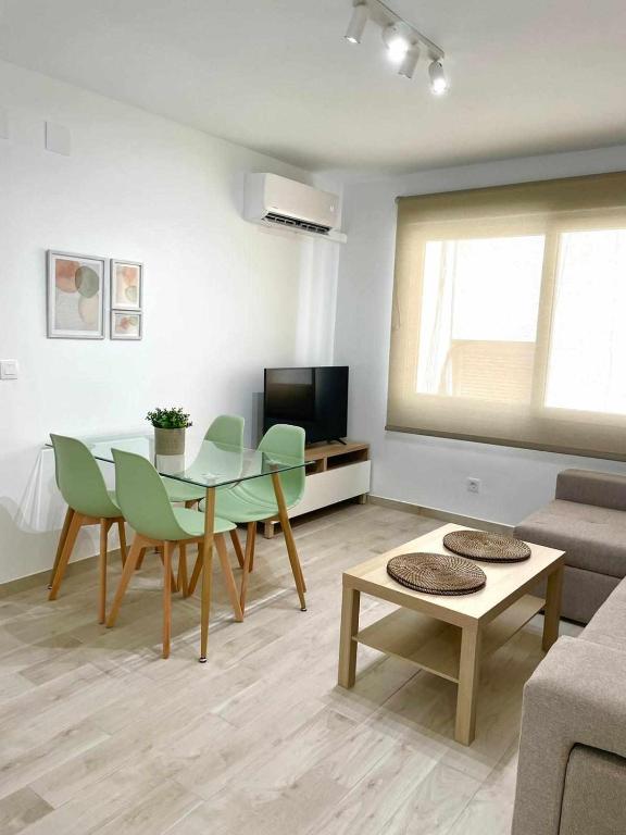 uma sala de estar com uma mesa e cadeiras verdes em Piso Azonaicas Centro Tendillas em Córdoba