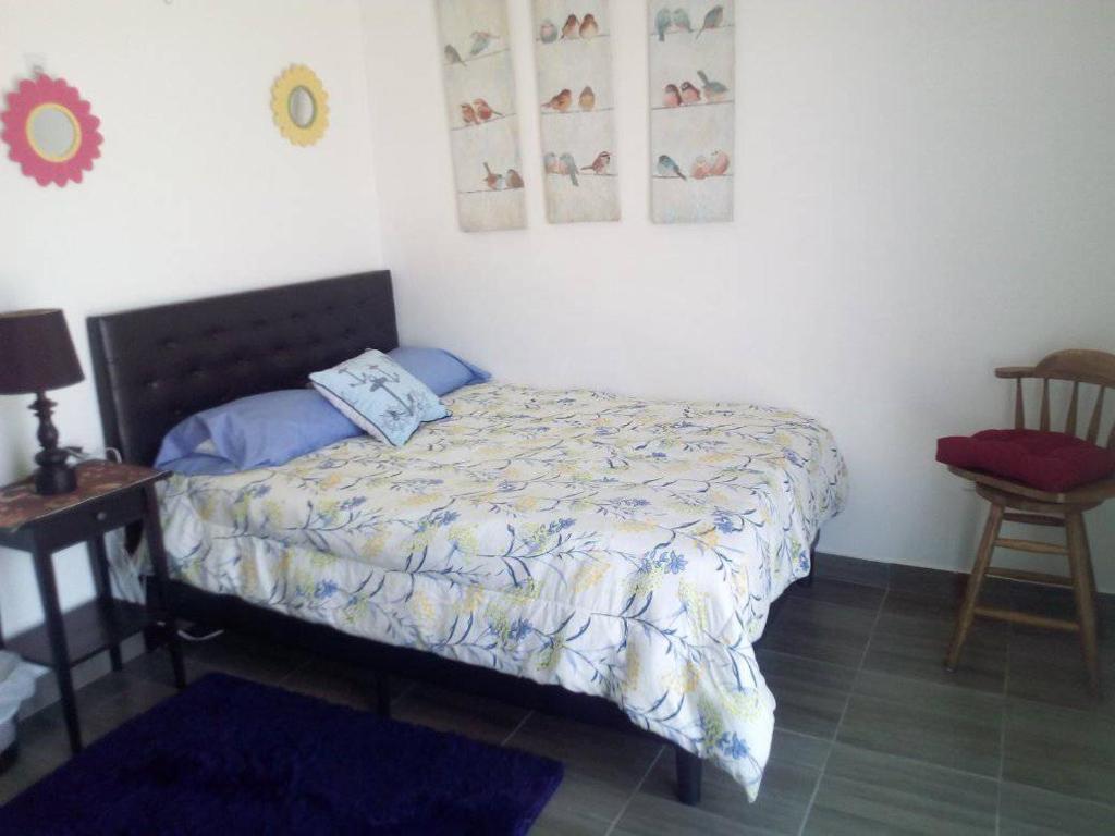 羅薩里托的住宿－Monte Mar，卧室配有1张床、1张桌子和1把椅子