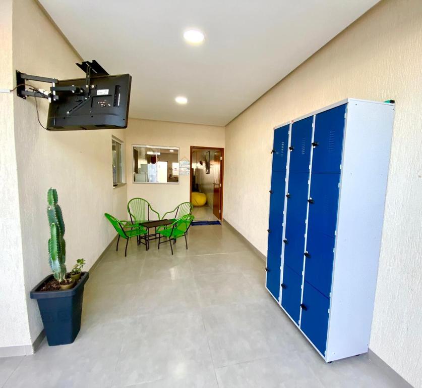 a hallway with a blue locker and a table and chairs at Hostel Flor de Carajás in Parauapebas