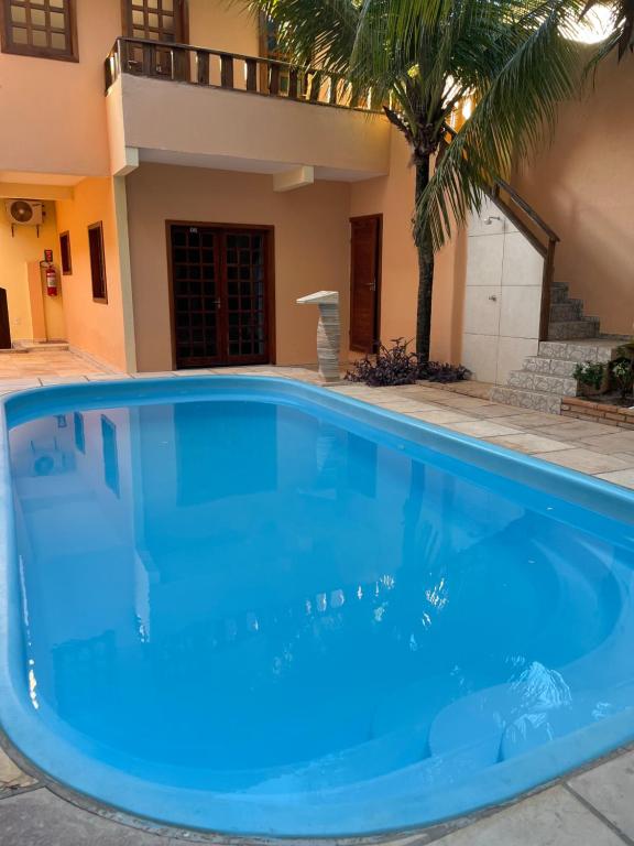 a large blue swimming pool in front of a house at Hotel Alta Vista in Canoa Quebrada