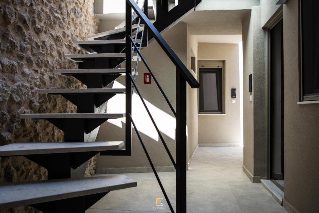 a staircase in a building with a stone wall at Uni Island - Old Town Suites in Heraklio