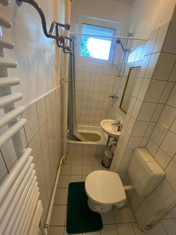 La petite salle de bains est pourvue de toilettes et d'un lavabo. dans l'établissement Hubert, à Berlin