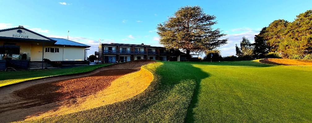 una casa en un campo de golf con un camino de tierra en Shepparton Golf Motel en Shepparton