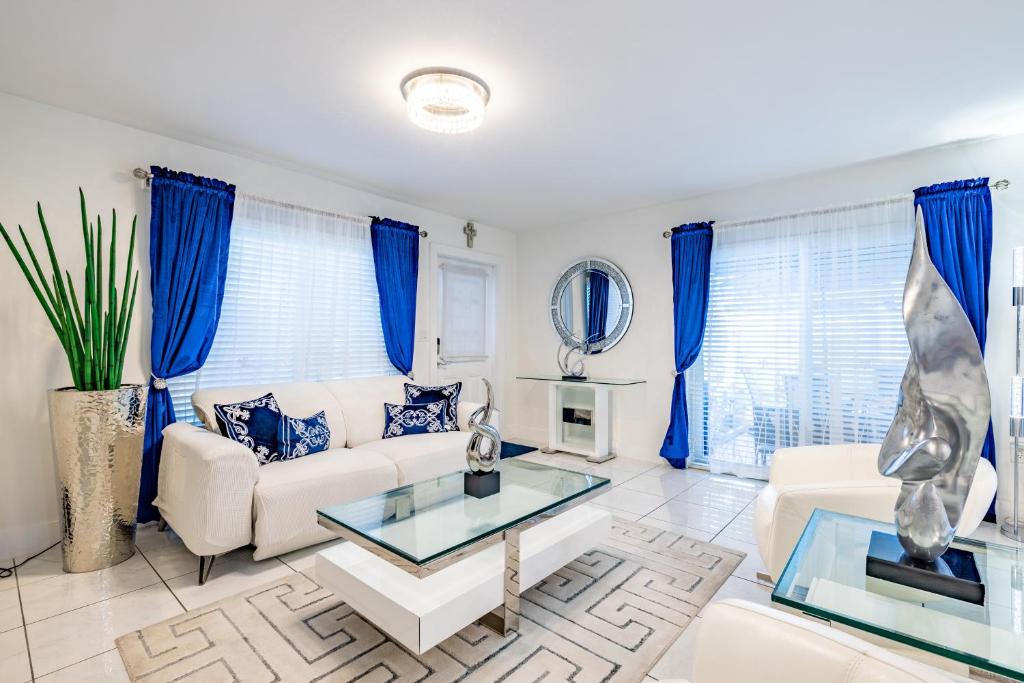 een woonkamer met blauwe gordijnen en een witte bank bij Luxurious and cozy Townhouse 3 bedrooms 2.5 Bath in Miami