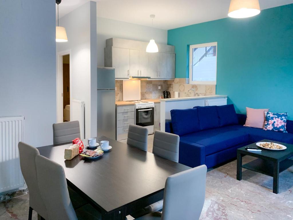 - un salon avec une table et un canapé bleu dans l'établissement Nyx Apartments, à Ancient Epidavros