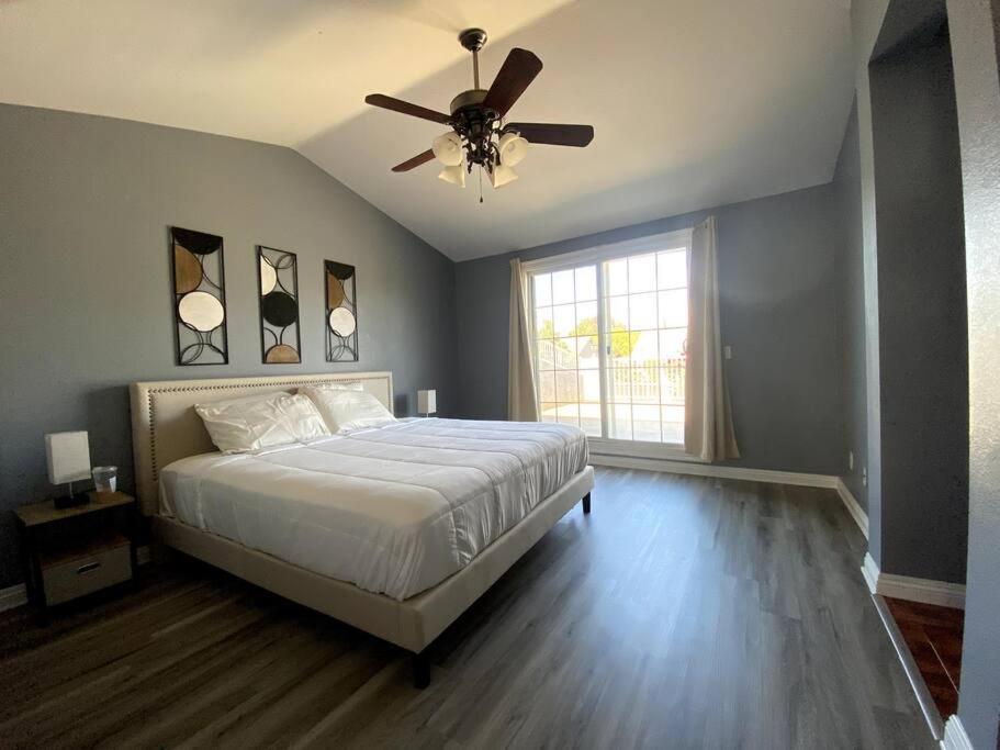 een slaapkamer met een bed en een plafondventilator bij HUGE GORGEOUS UPGRADED HOME IN THE CENTER OF SOCAL in Loma Linda