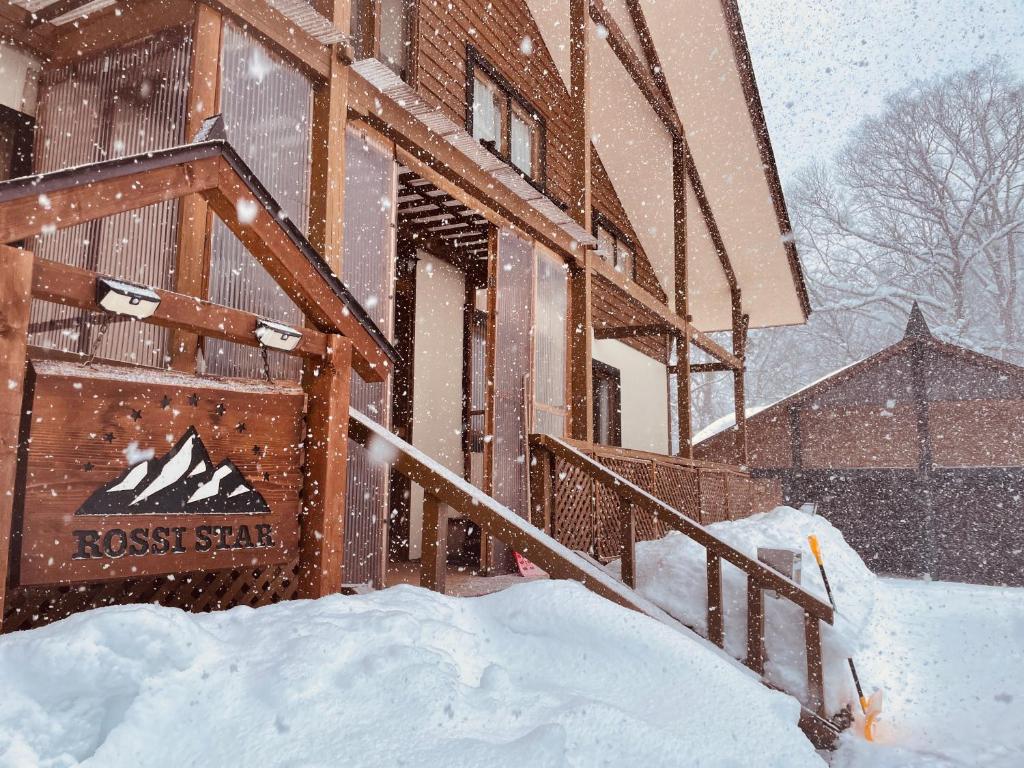 a building in the snow with a pile of snow at ROSSI STAR in Hakuba