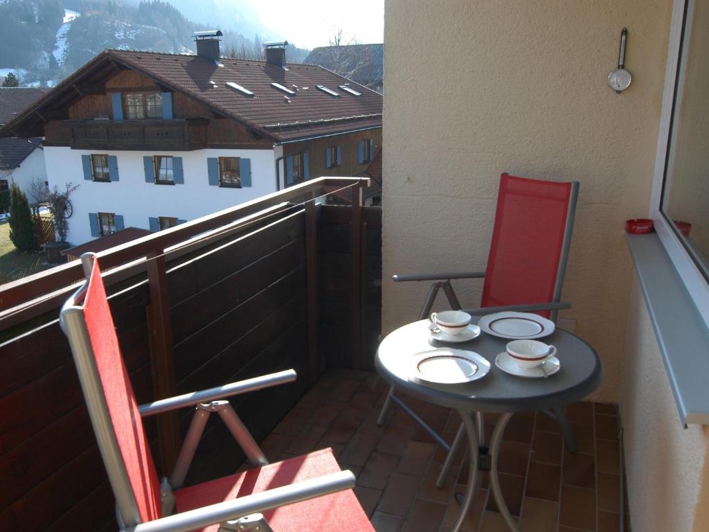 een kleine tafel en 2 stoelen op een balkon bij Ferienwohnung Breitenbergblick in Pfronten