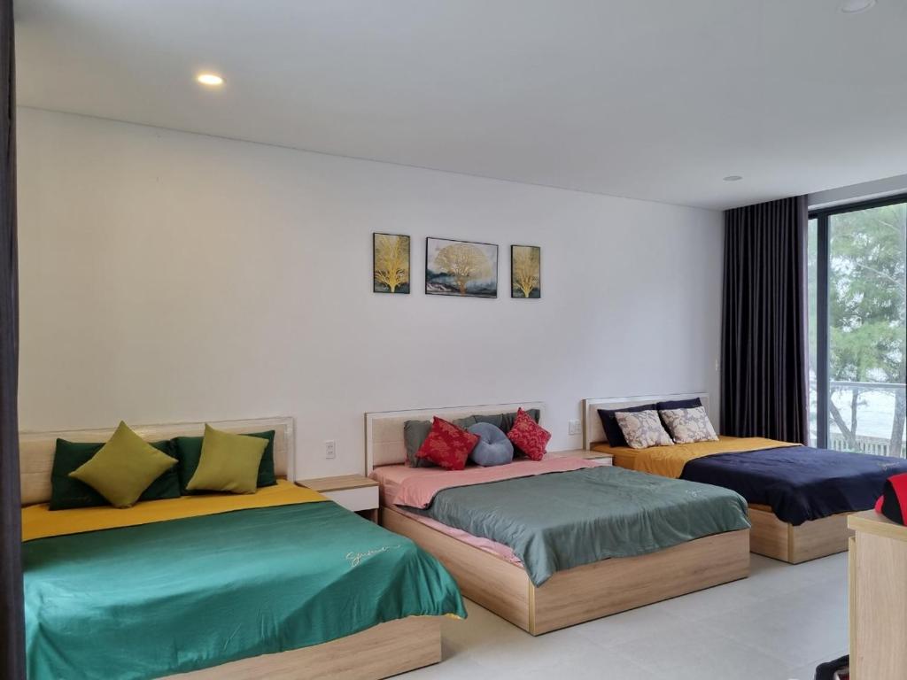 duas camas com almofadas coloridas num quarto em Villa Zenna Long Hải - Mimosa 611 View Biển em Long Hai