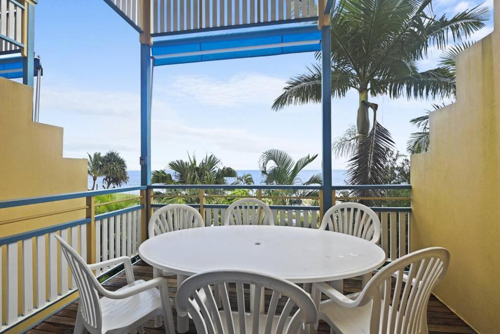 a table and chairs on a balcony with a view of the ocean at Villa 52 Tangalooma in Tangalooma