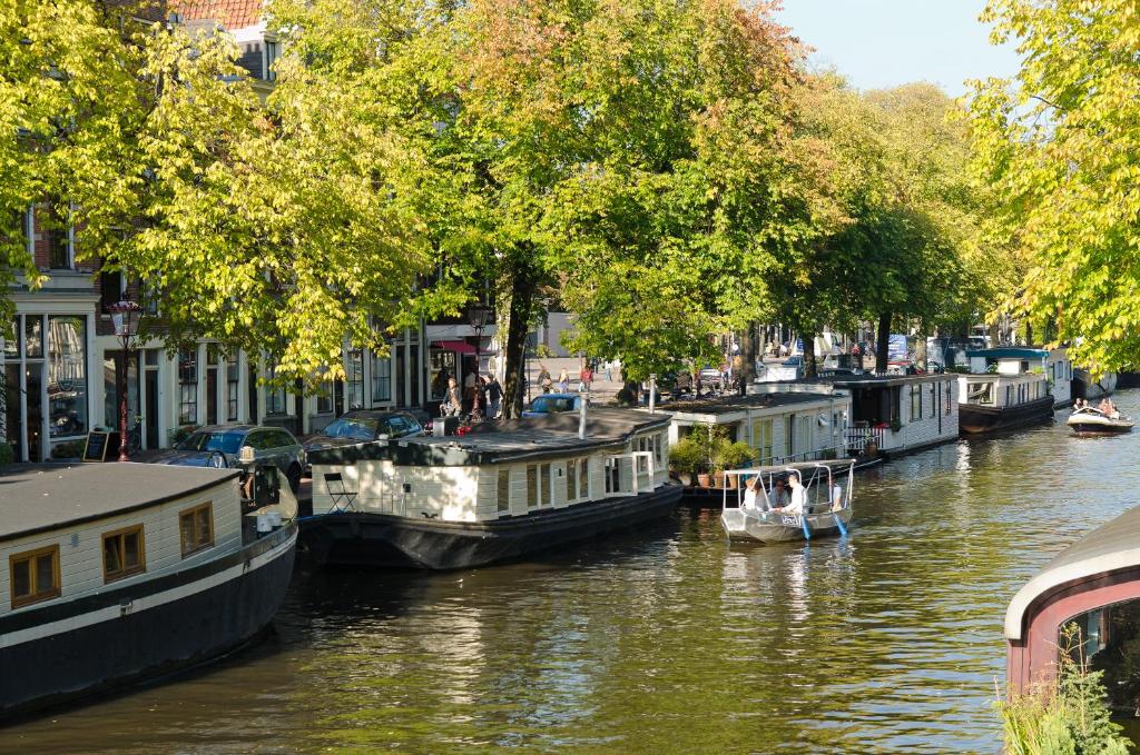 een groep boten is aangemeerd op een rivier bij Houseboat Prince-Avalon in Amsterdam