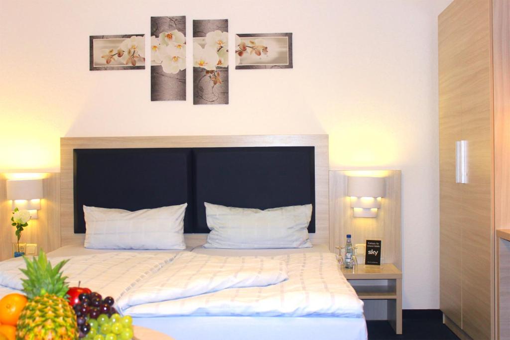 a hotel room with a bed with fruit on a table at Hotel Altenwerder Hof in Hamburg