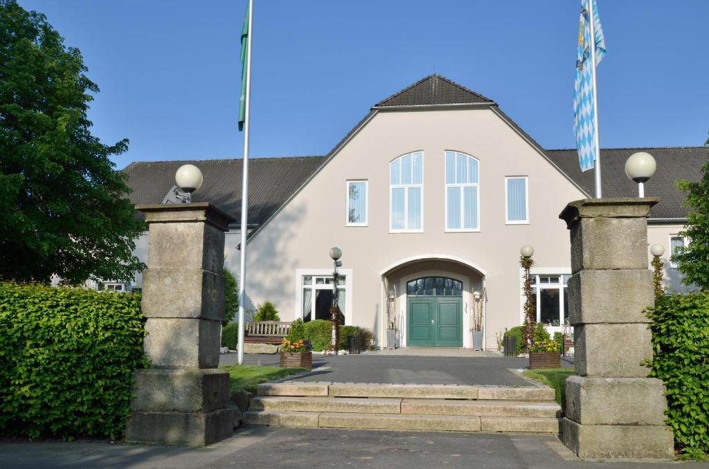 une grande maison blanche avec une porte verte dans l'établissement Golfhotel Fahrenbach, à Tröstau