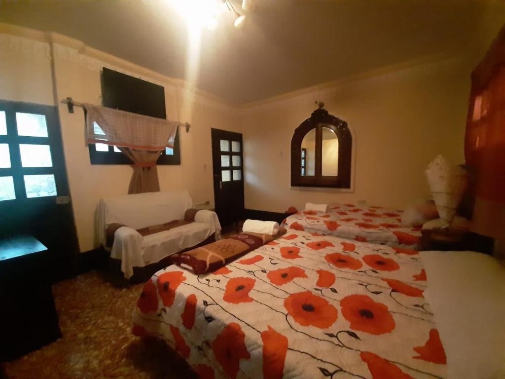 a bedroom with a large bed with a floral comforter at CASA EL CALVARIO in Antigua Guatemala