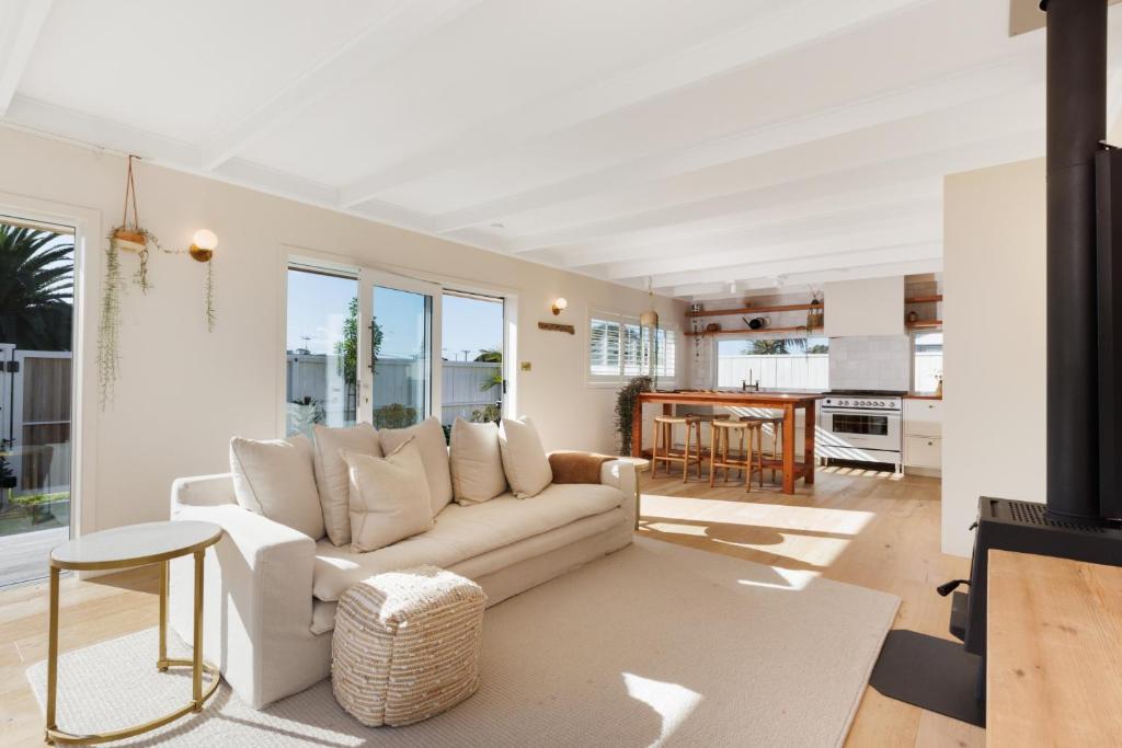 sala de estar con sofá y mesa en The Endless Summer Home - Beach and Town Location, en Mount Maunganui