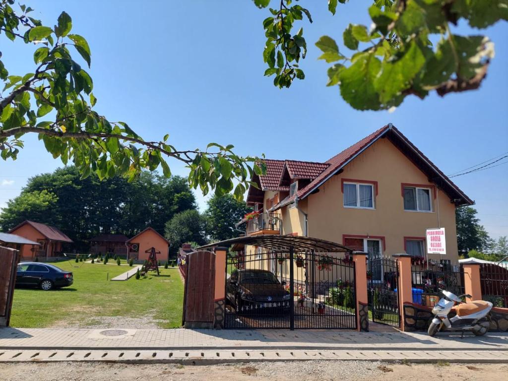 un parque infantil frente a una casa con una puerta en Pensiunea Sonia, en Cârţişoara