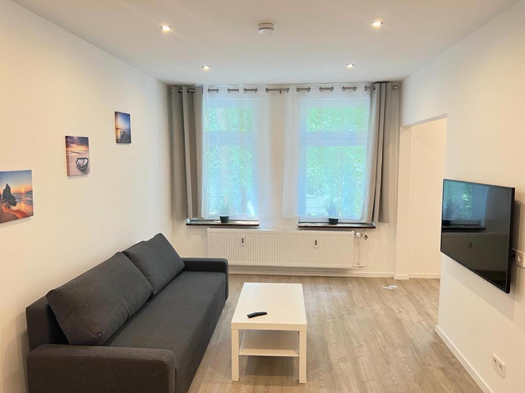 a living room with a couch and a tv at Zentrale und schöne Ferienwohnung II in Lübeck