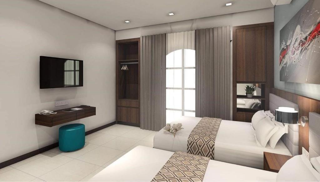 una camera d'albergo con due letti e una televisione di Beryll Inn Cyberjaya Hotel a Cyberjaya