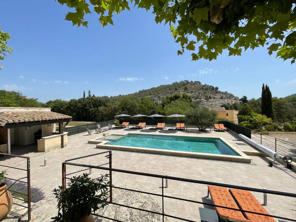 una piscina in un resort con una montagna sullo sfondo di Domaine de Calypso & Suites - Adult Only ad Auriol