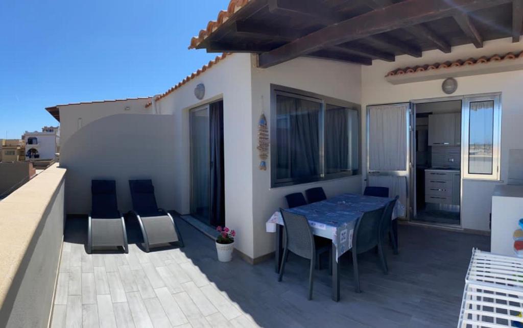 d'une terrasse avec une table et des chaises sur un balcon. dans l'établissement Appartamenti in paese a poca distanza dal mare, à Lampedusa