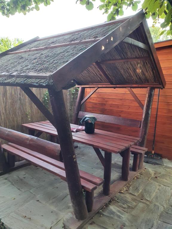 un banc en bois avec une tasse sur le dessus dans l'établissement Sunshine Apartment Velence, à Velence