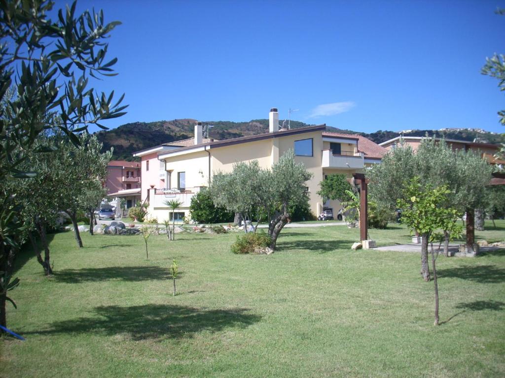 una casa en un patio con árboles delante de ella en Villa Toti, en Montepaone