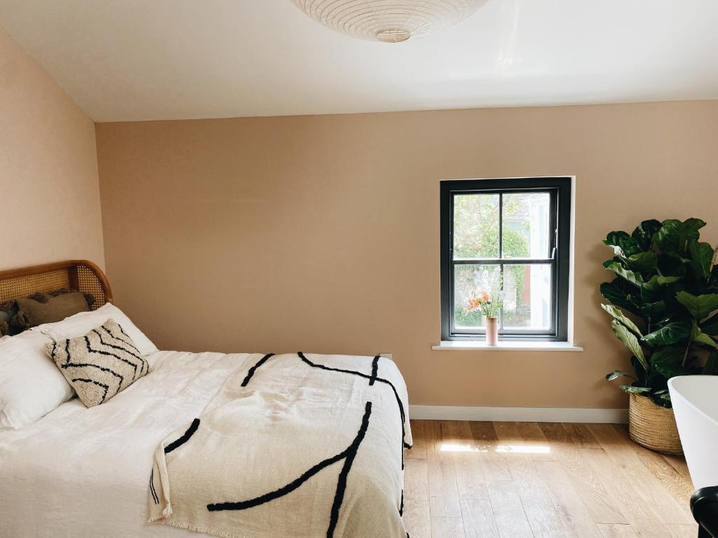 a bedroom with a bed and a window at Luxury bolthole in central St.Agnes with parking. in St. Agnes